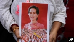 Seorang pedemo menunjukkan foto mantan pemimpin Myanmar, Aung San Suu Kyi, dalam demonstrasi di luar Kedutaan Besar Myanmar di Bangkok, Thailand, untuk memperingati dua tahun penggulingan pemerintahan sipil oleh militer, 1 Februari 2023. (Foto: Sakchai Lalit/AP Photo)