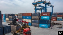 FILE - In this photo released by Xinhua News Agency, a truck transfers a container at the Tuanjiecun Station in the Chongqing International Logistics Hub Park in southwest China's Chongqing Municipality on May 5, 2024. 