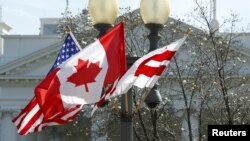 A Canadian flag flutters between a U.S. flag and a Washington, D.C., flag in front of the White House in Washington, March 7, 2016. Preparations are under way for the official state visit of Canada's Prime Minister Justin Trudeau on Thursday. 