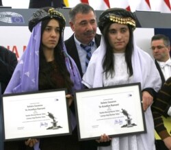 FILE - Yazidi women from Iraq, Nadia Murad Basee, left, and Lamiya Haji Bashar, pose with their award after receiving the European Union's Sakharov Prize for human rights at the European Parliament in Strasbourg, France, Dec. 13, 2016.