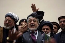 Afghan presidential candidate Abdullah Abdullah, center, addresses the media following a meeting with his party members, in Kabul, Afghanistan, Feb. 18, 2020.