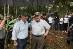 Colombia's President Ivan Duque, left, and Howard Buffett laugh during a tour of a cocoa farm in La Gabarra, Colombia. The Howard G. Buffett Foundation has committed to spending $200 million over the next few years to develop the municipality.