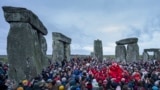 FILE - People celebrate the Winter Solstice sunrise celebrations at Stonehenge, England, Saturday, Dec. 21, 2024. (AP Photo/Anthony Upton)