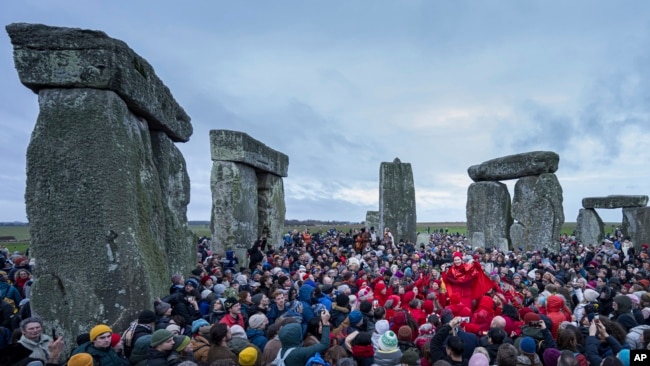 FILE - People celebrate the Winter Solstice sunrise celebrations at Stonehenge, England, Saturday, Dec. 21, 2024. (AP Photo/Anthony Upton)