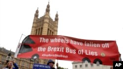 Anti-Brexit campaigner Steve Bray, centre, holds a banner near Parliament in London, Monday, Sept. 9.