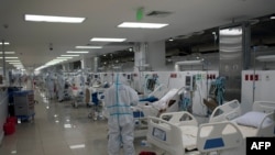 Trabajadores de la salud, voluntarios españoles de la Fundación SAMU y médicos salvadoreños asisten a pacientes ingresados en la unidad de cuidados intensivos durante la pandemia de COCIVD-19, en San Salvador, el 12 de agosto de 2020. 