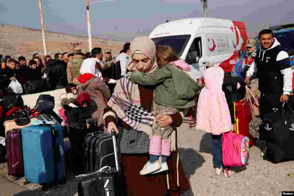 Syrian migrants wait at the Cilvegozu border gate to cross into Syria, after Syrian rebels announced that they have ousted President Bashar al-Assad, in the Turkish town of Reyhanli in Hatay province. REUTERS/Dilara Senkaya