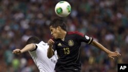 El mexicano Severo Meza (der.) y el estadounidense Herculez Gomez pelean por el balón en un partido clasificatorio de la Copa Mundial 2014.