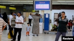FILE - Passengers are seen in a hall at Tripoli's Mitiga International Airport. 