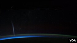 Foto NASA menunjukkan komet Lovejoy terlihat dekat horizon Bumi pada 21 December 2011 malam hari. Foto diambil dari Stasiun Antariksa Internasional (ISS).