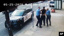 FILE - Minneapolis police Officers Thomas Lane, left, and J. Alexander Kueng, right, escort George Floyd, center, to a police vehicle outside Cup Foods in Minneapolis, on May 25, 2020, in this image from video.