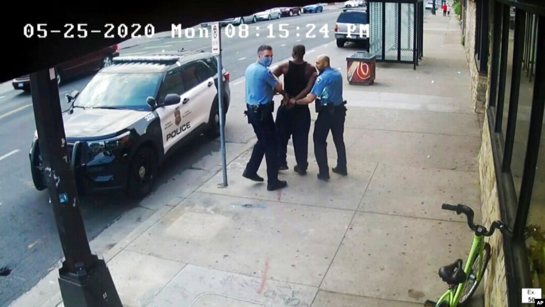 FILE - Minneapolis police Officers Thomas Lane, left, and J. Alexander Kueng, right, escort George Floyd, center, to a police vehicle outside Cup Foods in Minneapolis, on May 25, 2020, in this image from video.