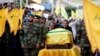 Brothers of top Hezbollah commander Mustafa Badreddine, who was killed in an attack in Syria, mourn over his coffin during his funeral in Beirut's southern suburbs, Lebanon, May 13, 2016