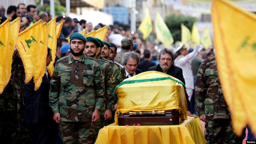 Brothers of top Hezbollah commander Mustafa Badreddine, who was killed in an attack in Syria, mourn over his coffin during his funeral in Beirut's southern suburbs, Lebanon, May 13, 2016