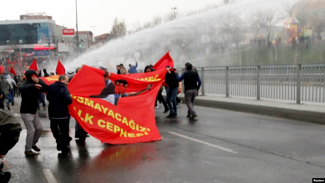 Protesters run from water cannons used by riot police to disperse them during a protest march to commemorate the death of Berkin Elvan, in Istanbul, March 11, 2015.