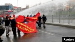 Protesters run from water cannons used by riot police to disperse them during a protest march to commemorate the death of Berkin Elvan, in Istanbul, March 11, 2015.