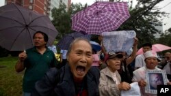 FILE - Petitioners with their own grievances shout support for Ji Zhongxing, Sept. 17, 2013. 