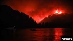 Api kebakaran hutan berkobar di Limni, Pulau Evia, Yunani, 6 Agustus 2021. (Foto: Sotiris Dimitropoulos/Eurokinissi via Reuters