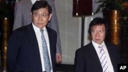 Sun Hung Kai Properties Joint Vice Chairmen and Managing Directors, Raymond and Thomas Kwok, walk outside their business headquarters in Hong Kong, April 3, 2012. 