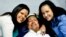 Venezuela's President Hugo Chavez smiles in between his daughters, Rosa Virginia (R) and Maria while recovering from cancer surgery in Havana in this photograph released by the Ministry of Information on February 15, 2013. Venezuela's government published