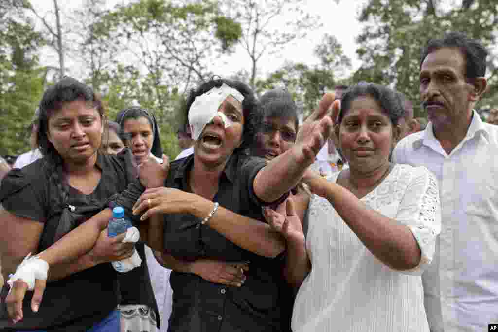 Anusha Kumari, center, weeps during a mass burial for her husband, two children and three siblings, all victims of Easter Sunday&#39;s bomb attacks, in Negombo, Sri Lanka.