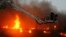 A fire fighter struggles to extinguish a fire at a garment factory in Karach