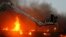 A fire fighter struggles to extinguish a fire at a garment factory in Karach