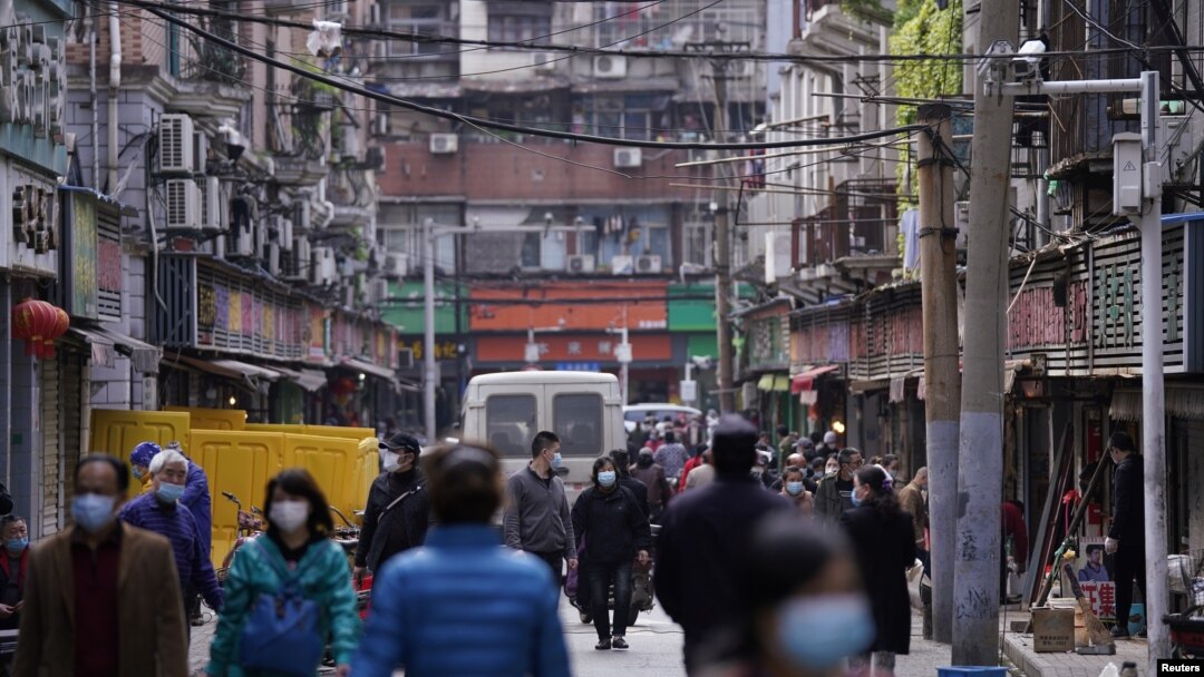 Para pejalan kaki mengenakan masker penutup wajah di Wuhan, 6 April 2020. 