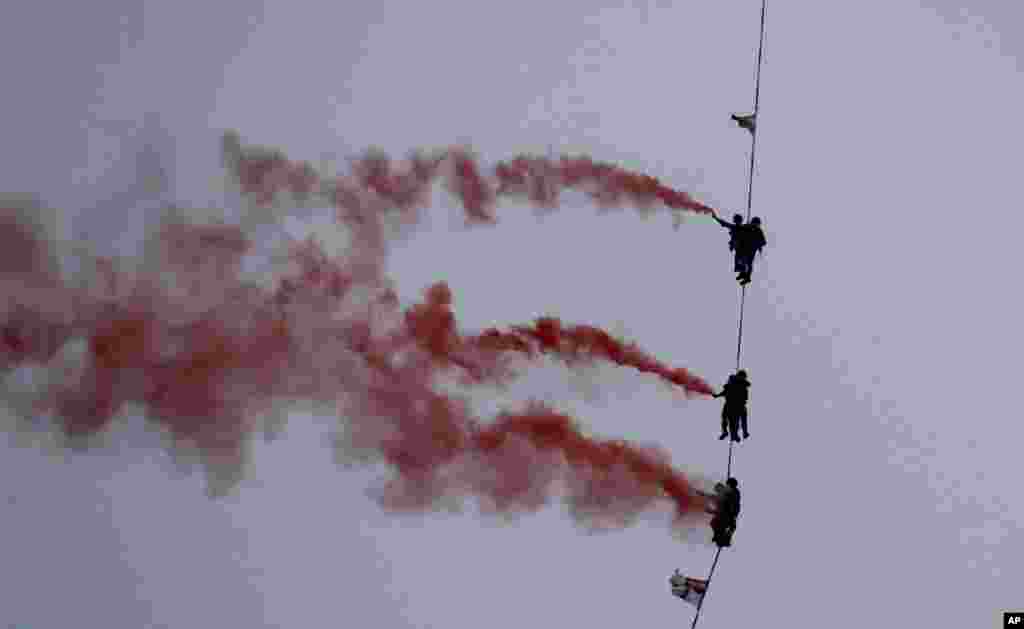Indian Navy personnel display their skills during a rehearsal for Naval Day celebrations at the Arabian Sea in Mumbai.