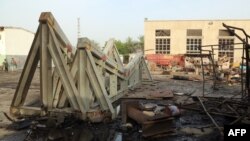 Workers inspect damages at the site of an air strike on the maintenance hub at the Hodeidah port on May 27, 2018.