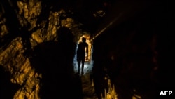 FILE - A man walks in a tunnel at a gold mine in El Callao, Bolivar state, Venezuela, March 1, 2017.