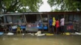 FILE - Children buy food at a shop in a flooded area where the Nile River overflowed after continuous heavy rain, which caused thousands of people to be displaced, in Bor, central South Sudan, Aug. 9, 2020. 