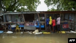 FILE - Children buy food at a shop in a flooded area where the Nile River overflowed after continuous heavy rain, which caused thousands of people to be displaced, in Bor, central South Sudan, Aug. 9, 2020. 