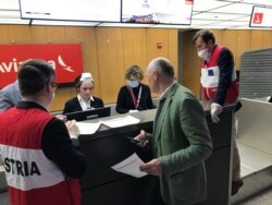 Martin Weiss, ambassador of Austria to the U.S. (in green jacket), seen here at the Austrian Airlines ticket counter March 23, 2020, as he helps ensure all goes smoothly as 300 Austrians head home.