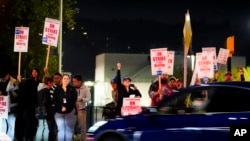 Trabajadores de Boeing gesticulan en dirección a un automóvil que toca la bocina en señal de apoyo después de que los miembros del sindicato votaron abrumadoramente para rechazar una oferta de contrato e ir a la huelga el 13 de septiembre de 2024 en Renton, Washington.