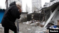 A woman reacts as she stands at a market that, according to locals, was recently damaged by shelling, in Donetsk, eastern Ukraine, Jan. 19, 2015. 