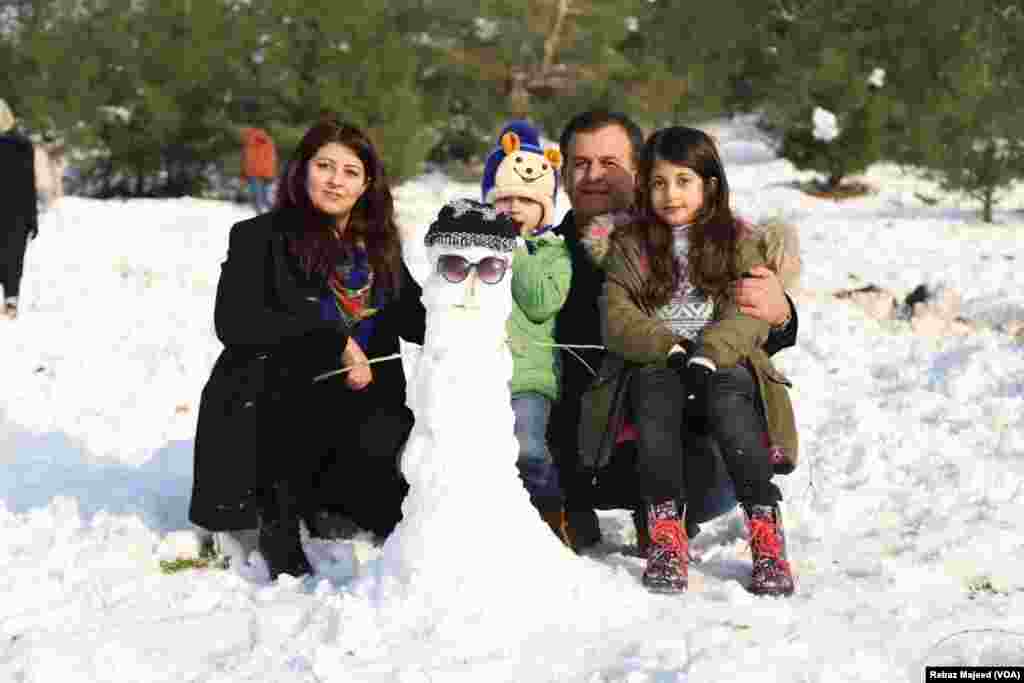 خێزانێک لە ناو بەفردا کاتێکی خۆش بەسەر دەبەن