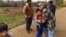 Caroline Clarin, right, hugs Haiwad Massoodi on a visit by his father, Sami, rear left, and Sami Massoodi's cousin Ihsanullah Patan, right, and Patan's son, Ali, at her farm in Dalton, Minn.Oct. 30, 2021.