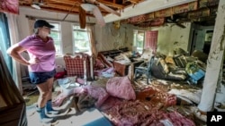 Cindy White looks over the devastation inside her home caused by Hurricane Helene in Morganton, North Carolina, Oct. 1, 2024. President Joe Biden will survey hurricane damage when he visits North Carolina on Wednesday.  