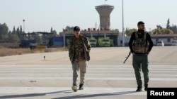 Members of the Kurdish-led Syrian Democratic Forces walk at Qamishli international airport in Qamishli, Syria, Dec. 9, 2024. 