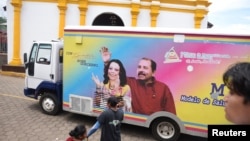 ARCHIVO - Una clínica móvil con una imagen del presidente nicaragüense Daniel Ortega y la vicepresidenta Rosario Murillo pasa por la iglesia de San Juan Bautista durante las festividades, en San Juan de Oriente, Nicaragua, el 24 de junio de 2024.