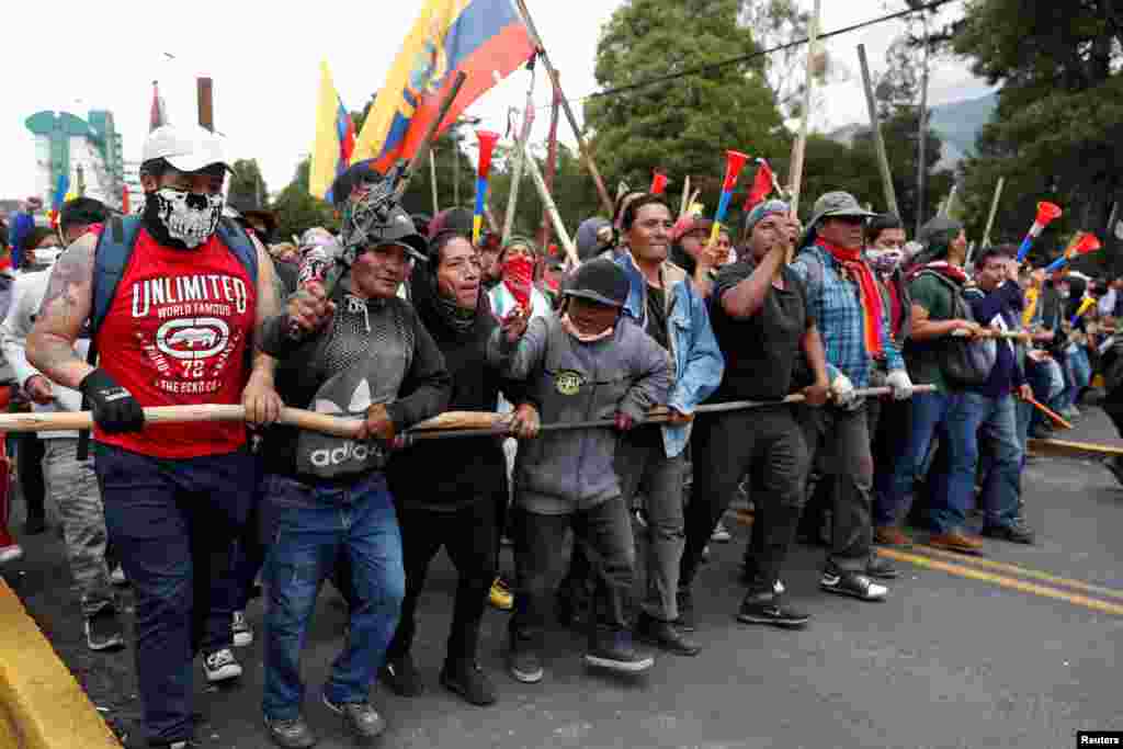 Manifestantes hacen una barrera humana ayudados por maderos en las calles de Quito, Ecuador. Octubre 8, 2019. REUTERS/Carlos Garcia Rawlins.