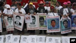 Kerabat dari 43 siswa sekolah guru yang hilang memegang poster dengan foto-foto orang-orang yang mereka cintai dalam aksi protes memperingati lima tahun menghilangnya para siswa tersebut, di Mexico City, Kamis, 26 September 2019.