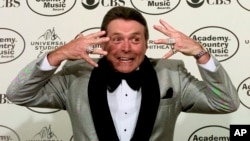 FILE - Presenter Mickey Gilley shows off his diamond rings to the media during the 34th Annual Academy of Country Music Awards in Universal City, Calif., on May 5, 1999.