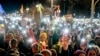 Germans hold up their cell phones as they protest the far-right Alternative for Germany party and right-wing extremism in front of the Brandenburg Gate in Berlin, Jan. 25, 2025.