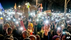 Germans hold up their cell phones as they protest the far-right Alternative for Germany party and right-wing extremism in front of the Brandenburg Gate in Berlin, Jan. 25, 2025.