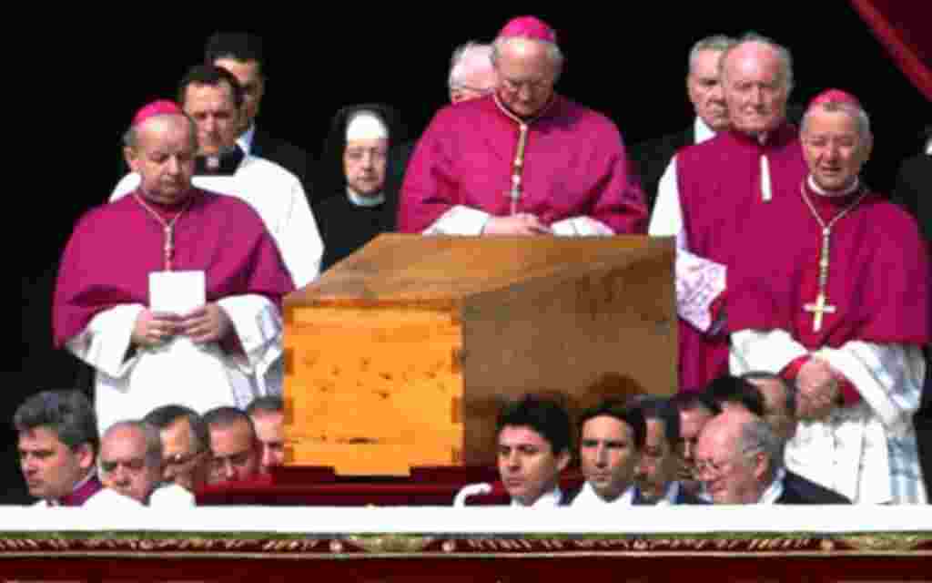 El sacerdote estadounidense James Harvey, reza frente al ataúd de el Papa Juan Pablo II durante la ceremonia de su funeral (2005).