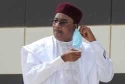 FILE - Niger President Mahamadou Issoufou takes off his face mask during the G5 Sahel summit in Nouakchott, June 30, 2020.