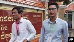 FILE - Journalists Uon Chhin, left, and Yeang Sothearin arrive at the municipal court in Phnom Penh, Cambodia, Aug. 30, 2019. 