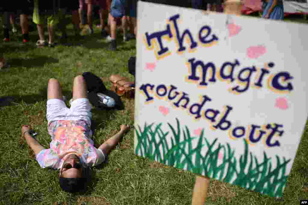 A reveler rests on the grass in the Healing Field area of the Glastonbury Festival of Music and Performing Arts on Worthy Farm near the village of Pilton in Somerset, Southwest England.
